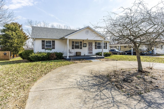 view of front of home with a porch, a front yard, and a shingled roof