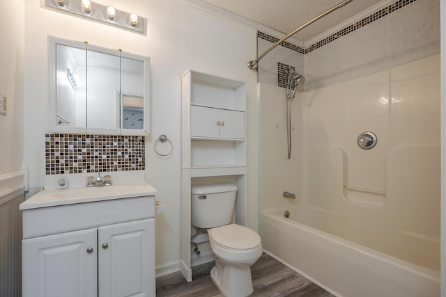 bathroom with vanity, wood finished floors, shower / bath combination, toilet, and tasteful backsplash