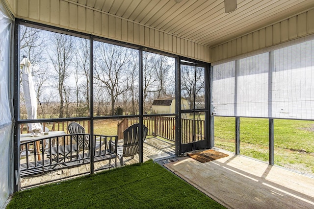 unfurnished sunroom with ceiling fan