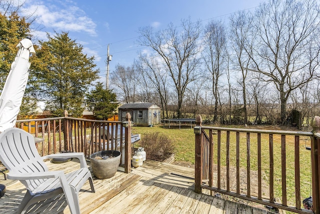 deck with a storage shed, an outdoor structure, a trampoline, and a lawn