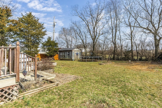 view of yard with an outdoor structure, a trampoline, and a shed