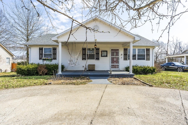 bungalow featuring covered porch and a shingled roof