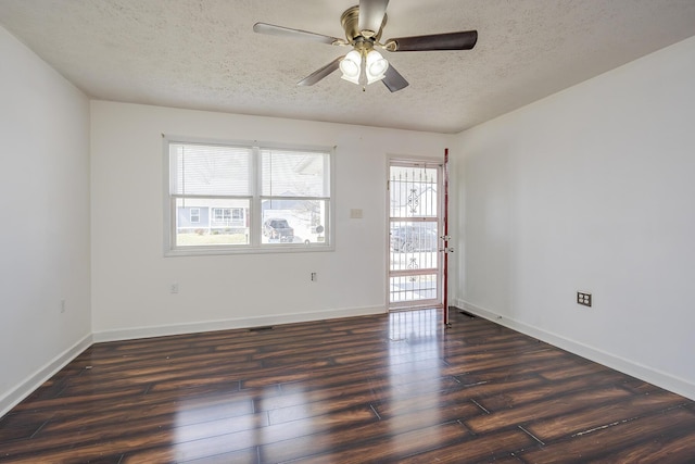 spare room with baseboards, a textured ceiling, dark wood-style floors, and a ceiling fan