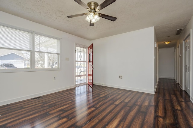 unfurnished room featuring baseboards, visible vents, ceiling fan, dark wood-type flooring, and a textured ceiling