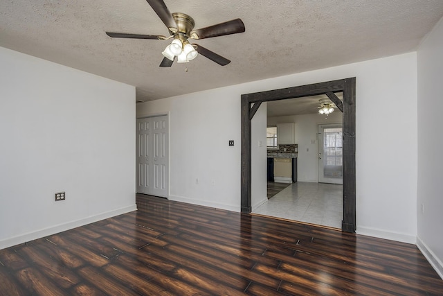 unfurnished living room with ceiling fan, baseboards, a textured ceiling, and wood finished floors