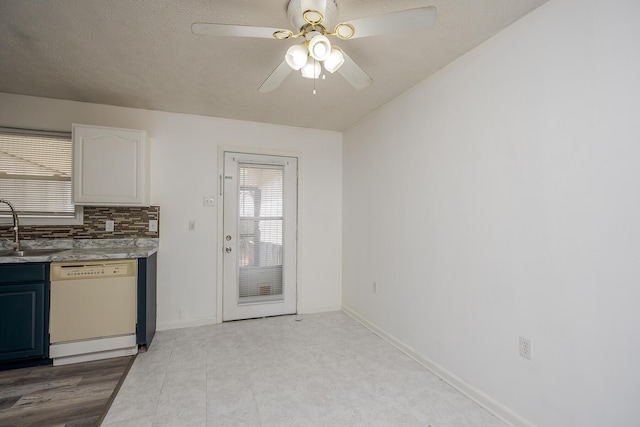 kitchen featuring a sink, backsplash, white dishwasher, light countertops, and ceiling fan