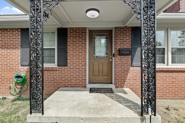 doorway to property featuring brick siding