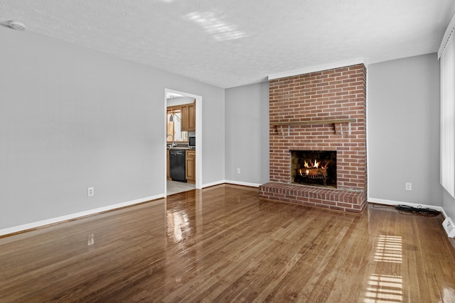 unfurnished living room with baseboards, wood finished floors, and a fireplace