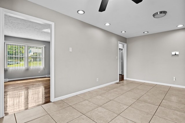 empty room featuring light tile patterned floors, recessed lighting, a ceiling fan, and baseboards