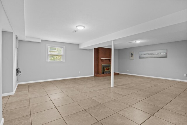 below grade area with visible vents, a fireplace, and baseboards