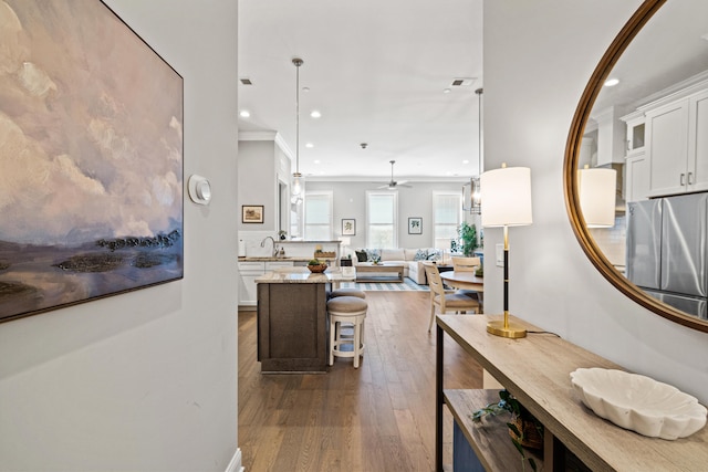 interior space featuring a center island, crown molding, dark wood finished floors, open floor plan, and white cabinets