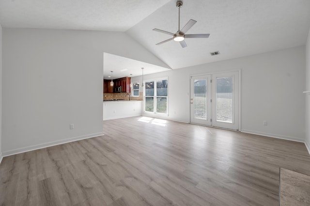 unfurnished living room with visible vents, baseboards, light wood-style floors, and a ceiling fan