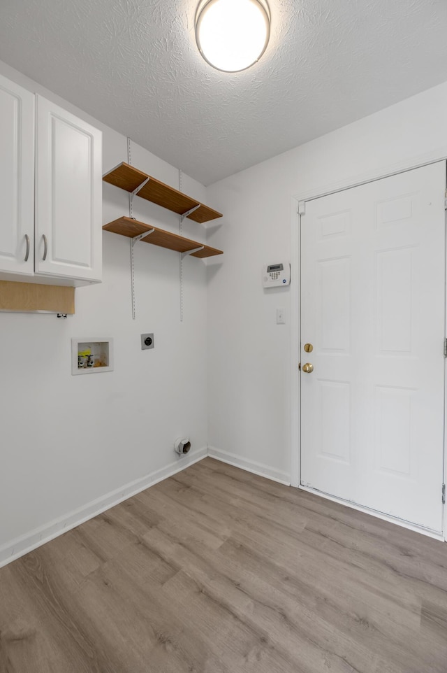 clothes washing area with a textured ceiling, hookup for an electric dryer, washer hookup, and light wood finished floors