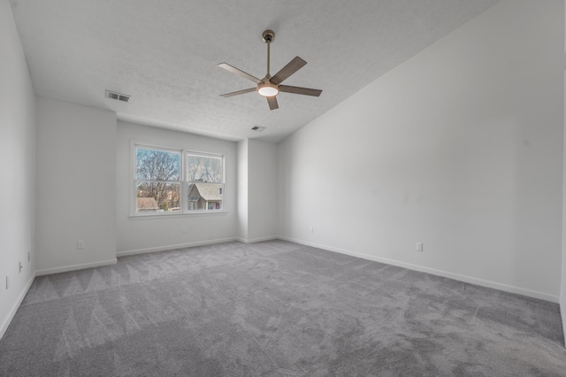 unfurnished room featuring visible vents, a textured ceiling, carpet floors, baseboards, and ceiling fan