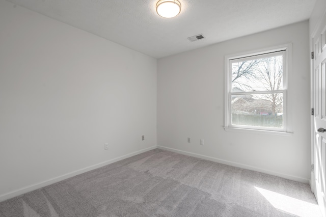 unfurnished room with visible vents, baseboards, and carpet flooring