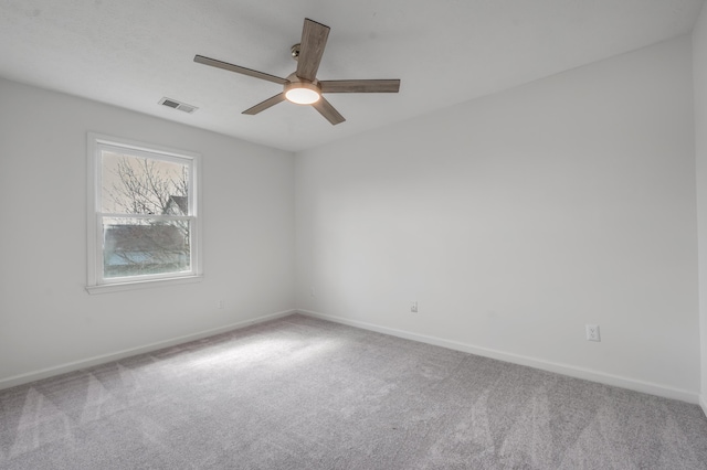 spare room featuring baseboards, visible vents, carpet floors, and ceiling fan