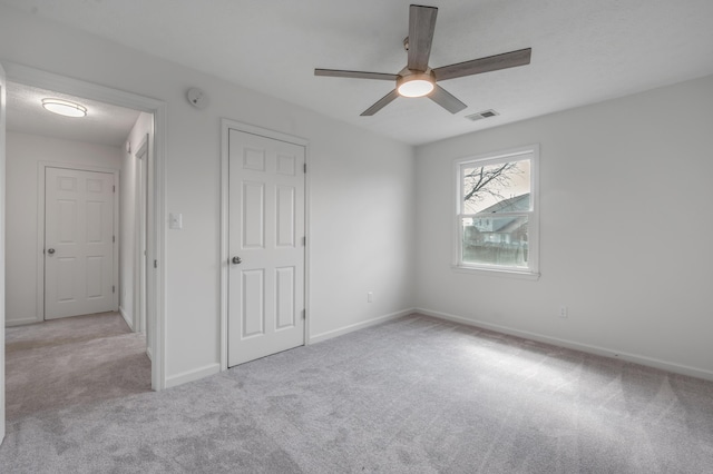 unfurnished bedroom featuring visible vents, baseboards, ceiling fan, and carpet flooring