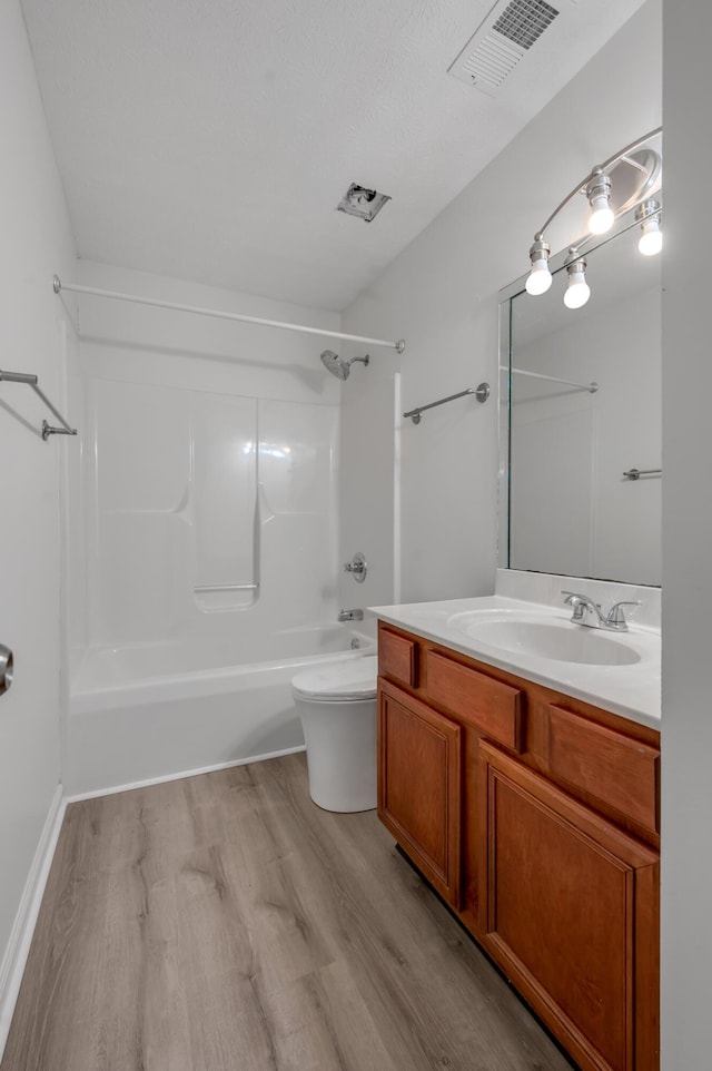 full bathroom with visible vents, toilet, vanity, and wood finished floors