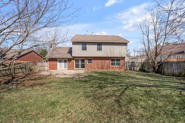 rear view of house featuring brick siding, a fenced backyard, and a lawn