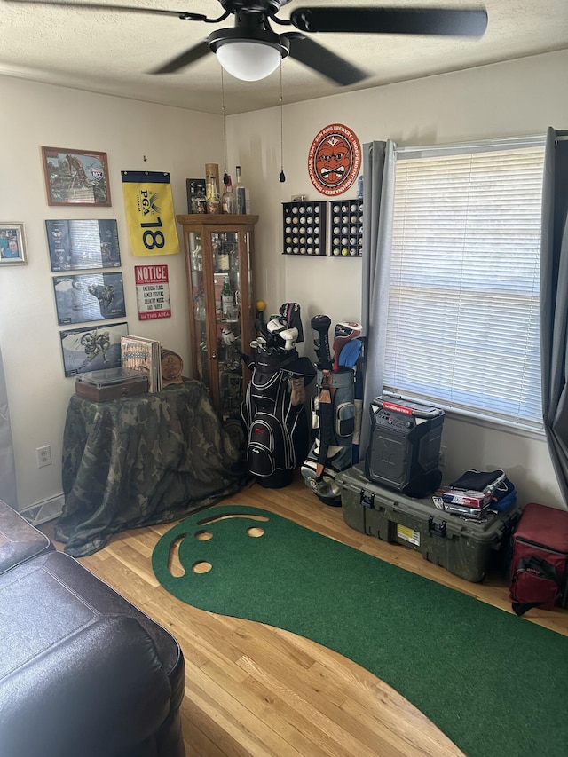 recreation room with wood finished floors and ceiling fan