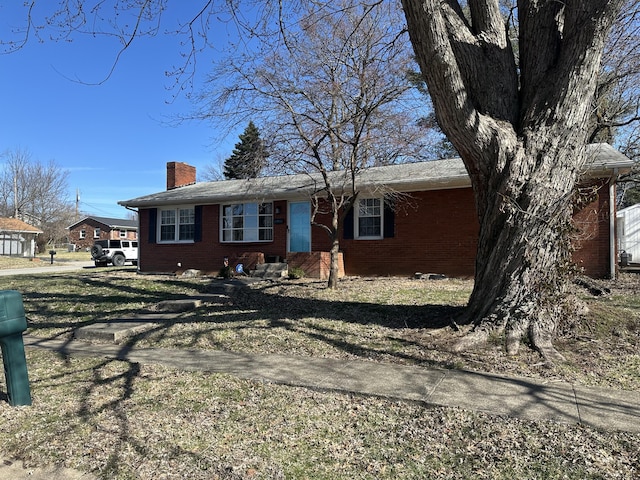 single story home with brick siding and a chimney