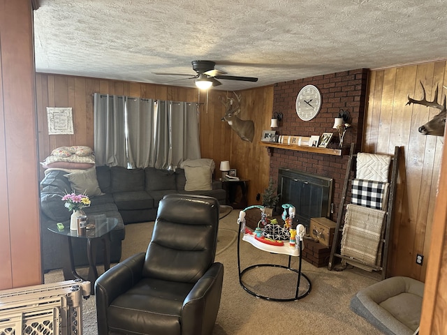 carpeted living room with wooden walls, a fireplace, and a textured ceiling