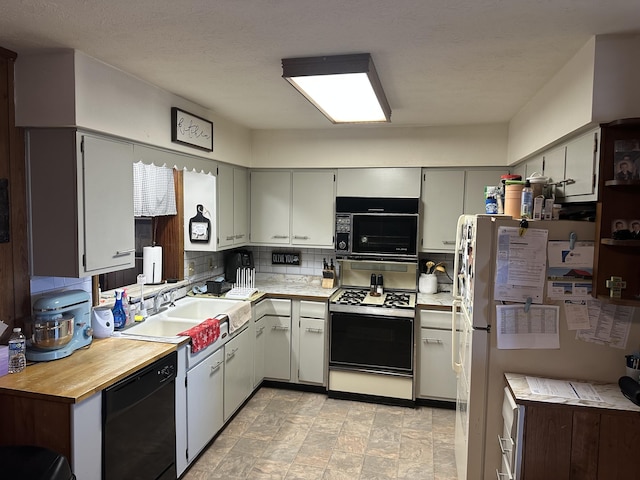 kitchen with tasteful backsplash, black appliances, light countertops, and a sink