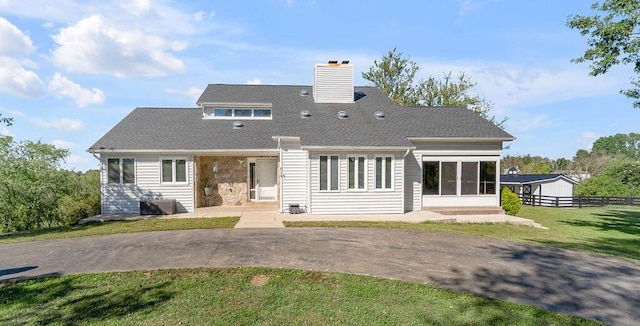 back of property with a lawn, a chimney, a patio, and fence