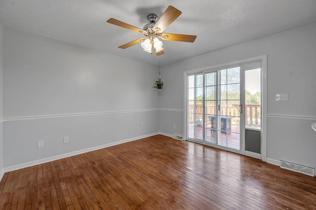 spare room with visible vents, baseboards, and hardwood / wood-style floors