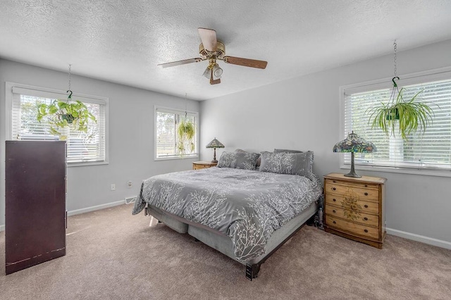 bedroom featuring ceiling fan, a textured ceiling, baseboards, and carpet