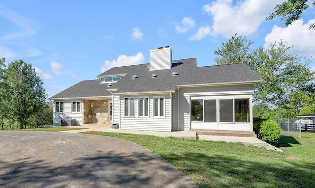 back of property featuring a patio, fence, roof with shingles, a chimney, and a lawn