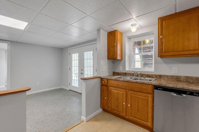 kitchen featuring dishwasher, brown cabinetry, a wealth of natural light, and a sink