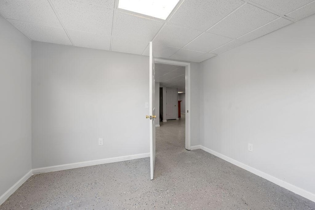 empty room with baseboards and a drop ceiling