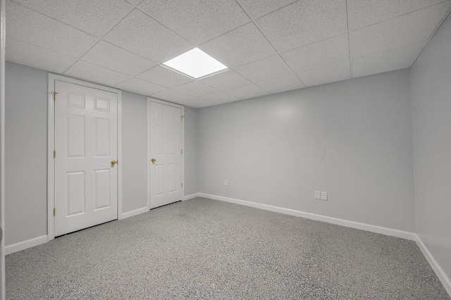 interior space featuring a drop ceiling and baseboards