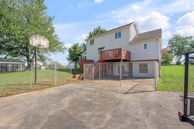 rear view of property featuring a yard, a patio, a wooden deck, and fence