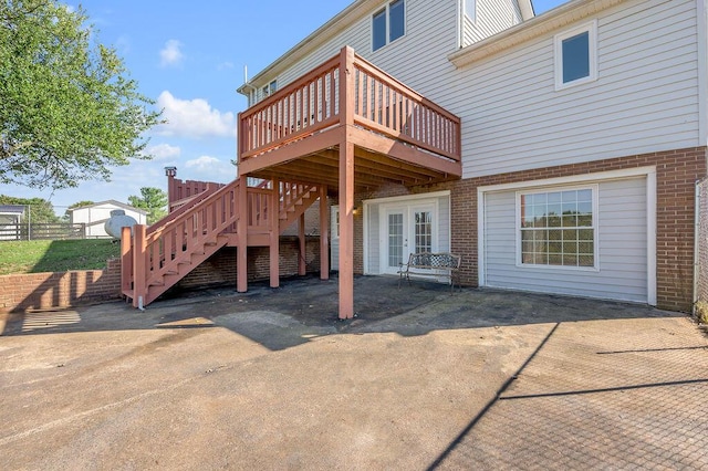 exterior space featuring brick siding, stairway, french doors, a deck, and a patio area