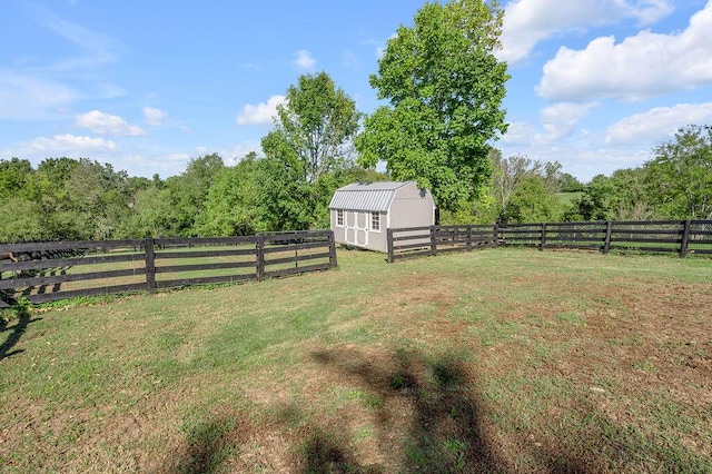 view of yard featuring a forest view, an outbuilding, a fenced backyard, and a rural view