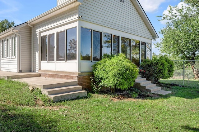 exterior space with a lawn and a sunroom