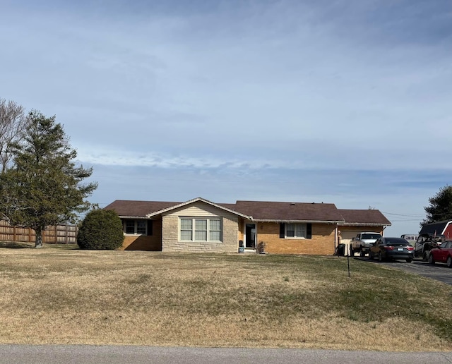 ranch-style home featuring a front yard and fence