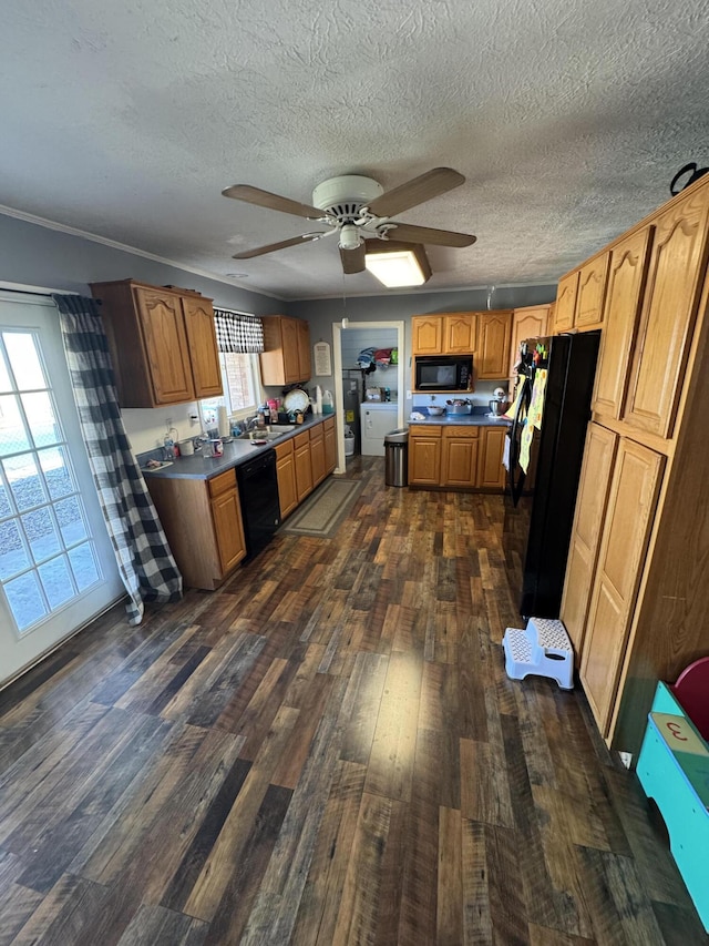 kitchen with brown cabinetry, dark wood-style floors, ceiling fan, black appliances, and a textured ceiling