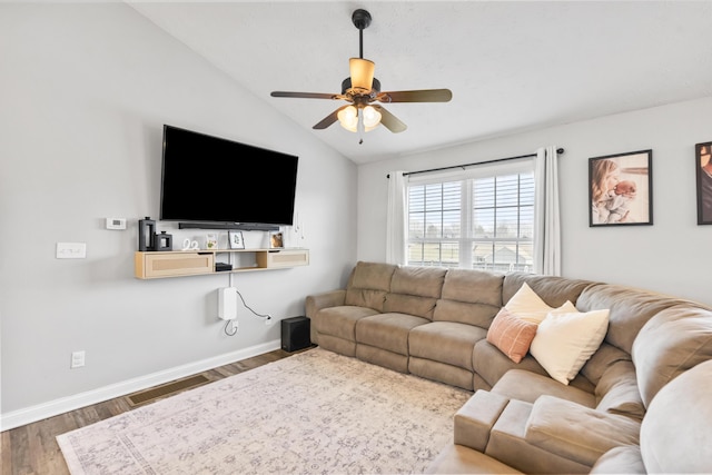 living room with a ceiling fan, wood finished floors, baseboards, visible vents, and vaulted ceiling