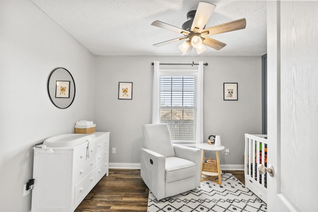 bedroom with ceiling fan, baseboards, a textured ceiling, and wood finished floors