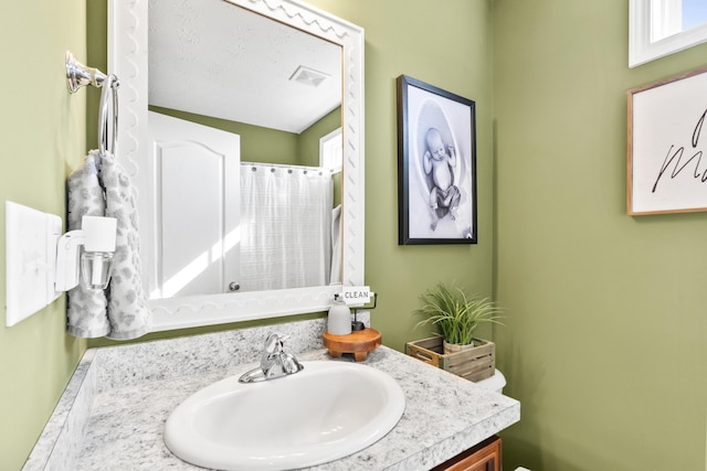 bathroom with visible vents, curtained shower, vanity, and toilet