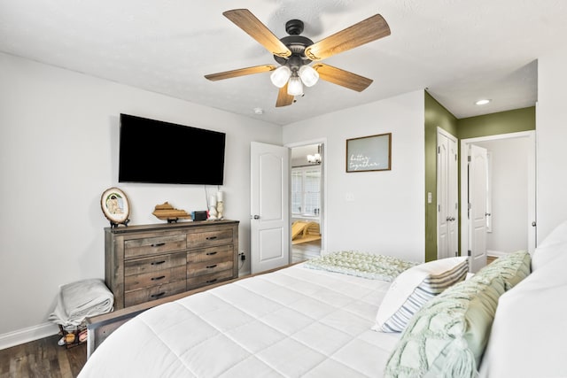 bedroom featuring a ceiling fan, wood finished floors, baseboards, and a closet