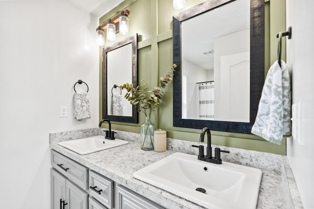 bathroom featuring double vanity, visible vents, and a sink