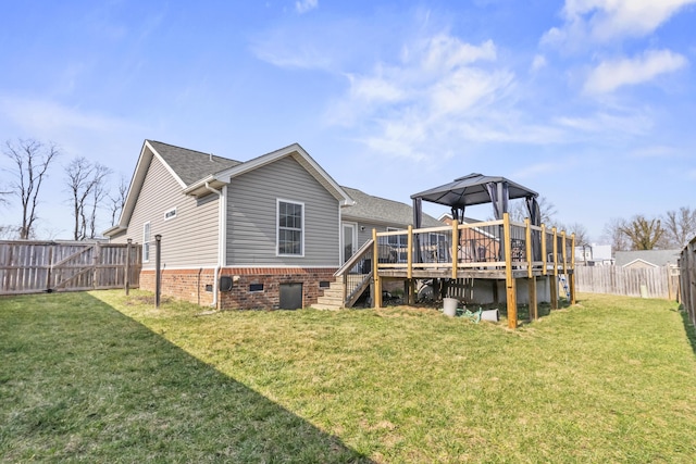 rear view of property with a lawn, a deck, a fenced backyard, stairway, and roof with shingles