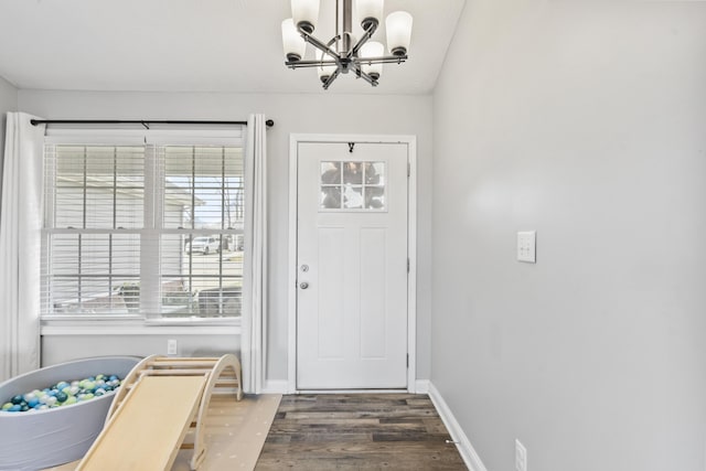 foyer with an inviting chandelier, wood finished floors, and baseboards