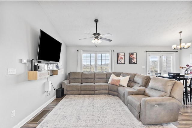 living room with dark wood finished floors, plenty of natural light, baseboards, and vaulted ceiling