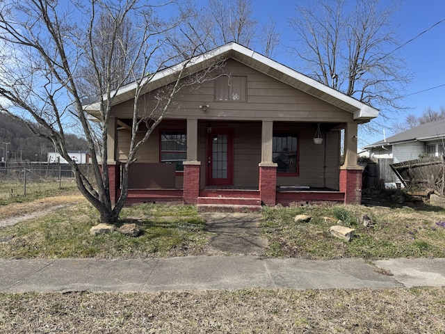 bungalow featuring a porch and fence