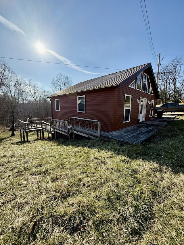 view of side of property with a wooden deck and a yard